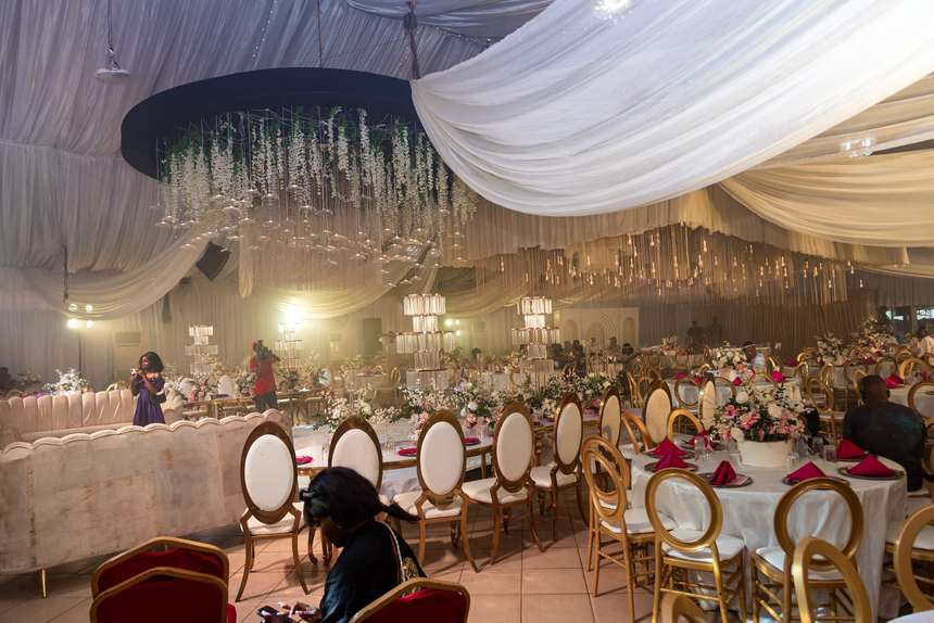 The draped canopy sweeping across the width of the marquee above a seated crowd.